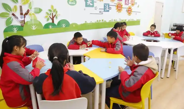 同学们正一起拼搭心情积木五颜六色的积木块在他们手中逐渐成型